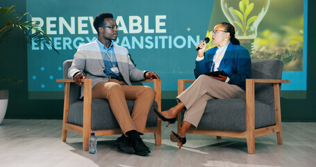 Man, woman and discussion on stage at conference for renewable energy, solution and global policy. People, questions and talk in public debate for sustainability, future or plan of action for planet