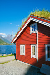 Canvas Print - Traditional Scandinavian houses with moss on the roof. Beautiful mountain lake in Norway. Nature in the fjords. Vacation and travel in summer Norway.