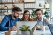 © WhimsyCreative - Three Business Colleagues Working Together on a Laptop in an Office Setting