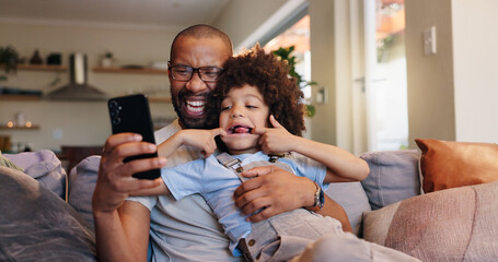 Wall Mural - Selfie, picture and father with funny face on sofa, smile and funny for social media comedy. Photography, memories and dad with child in home living room, bonding and happy for goofy fun with family