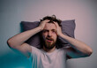 © phoenix021 - Top view man having trouble sleeping  head on a pillow hands on the head