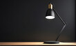 © Stanci - Black Desk Lamp With Gold Accents on a Wooden Table Against a Dark Wall