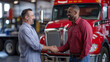 © Thumbs - Truck drivers shaking hands in front of a red truck, teamwork, logistics