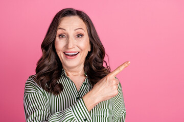 Wall Mural - Photo of nice aged lady direct finger empty space wear striped shirt isolated on pink color background