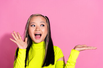 Sticker - Photo of ecstatic girl with dyed hair dressed yellow shirt look at palm demonstrate product empty space isolated on pink color background