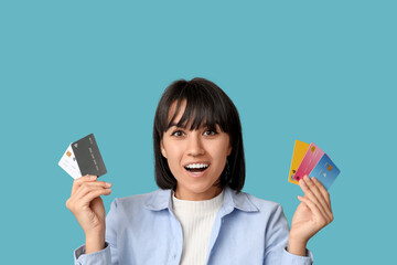 Sticker - Beautiful young woman with many credit cards on blue background