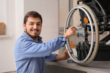 Sticker - Young man with wrench repairing wheelchair on table at home