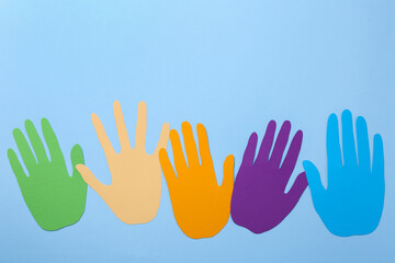 Wall Mural - Equality concept. Different paper palms on light blue background, flat lay. Space for text