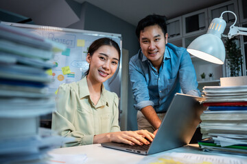 Wall Mural - Portrait of Asian businessman and woman smiling while work in office. 