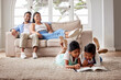 © Alex Shared/peopleimages.com - Happy family, relax and kids reading book in home for learning, bonding or knowledge together. Smile, education and parents with kid siblings storytelling for fairytale, fantasy or child development