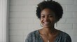 © VistaVisions - Portrait of young happy black african american woman smiling standing in front of blank white wall looks in camera