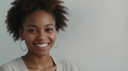 Wall Mural - Portrait of young happy black african american woman smiling standing in front of blank white wall looks in camera