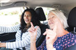 © Wavebreak Media - Two happy diverse senior female friends going on road trip smiling and talking in car
