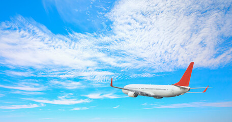 Wall Mural - White passenger airplane flying in the sky amazing clouds in the background - Travel by air transport