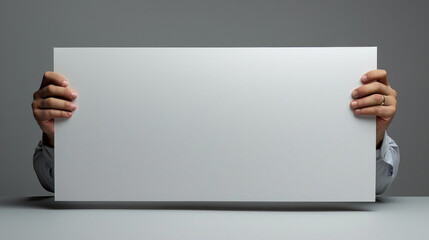 A person is holding a white sign in their hands. The sign is blank, and it could represent a blank slate or a new beginning