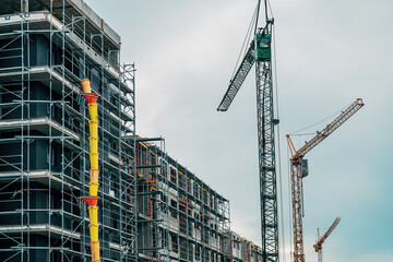 Wall Mural - Residential building construction site with cranes and scaffolding equipment