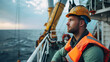© Sawyer0 - A wind turbine technician at an offshore farm, dressed in full safety kit, looks into the distance at the high seas.