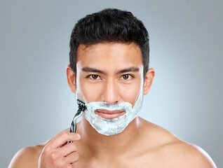 Poster - Portrait, shaving and skincare with masculine man in studio on gray background for cosmetic wellness. Beauty. dermatology and razor with face of confident person in bathroom for grooming or hygiene