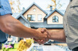 © Konstantin - A realtor shakes hands with a client as a sign of a successful sale of a private house.