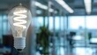 © LoLArt - Energy efficient bulb lamp close up photo in blurred light modern office illuminating office space with copyspace