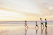 © peopleimages.com - Beach, family and sunrise with bonding and running with game, vacation and parents care. Kids, love and outdoor with travel, holiday and ocean with mom and dad by the sea with mockup together