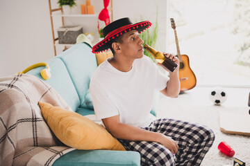 Sticker - Photo of cheerful dreamy guy sleepwear pajama mexican cap had cool bachelor party drinking beer indoors house apartment room