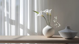Elegant white vase with lily flowers in a chic modern room interior.