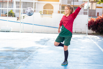 concepts: women's sports and outdoor recreation. young woman playing soccer kicks the ball in the ai