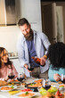 © Alessandro Grandini - Bearded man pouring wine for friends enjoying dinner party