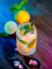 Wall Mural - refreshing cold summer cocktail with lemon and mint on a wooden table