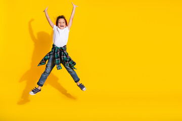 Poster - Full size photo of small charming boy raise hands jumping wear trendy white outfit isolated on yellow color background