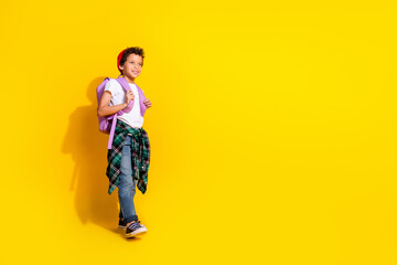 Poster - Full body photo of cute little boy backpack walk school dressed stylish white clothes isolated on yellow color background