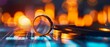 © apichat - Close-up image of a magnifying glass and coins on a circuit board with vibrant, out-of-focus city lights in the background.