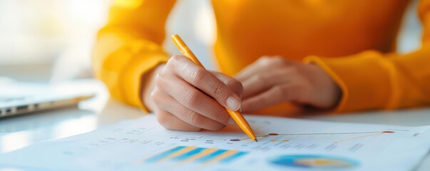 Close-up of a hand writing on a paper with a pencil.