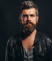 Sticker - Male beauty and fashion wear. Handsome bearded man in glasses and leather jacket. Portrait of serious man in black leather jacket. Fashionable male model with stylish hairstyle in demi-season clothes.