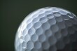 © ylivdesign - Close up of a white golf ball with dimples, resting on a green background