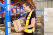 © DG PhotoStock - Female caucasian white warehouse worker inspecting the inventory.