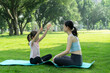 © onlyyouqj - Mom and daughter are doing yoga on the park lawn
