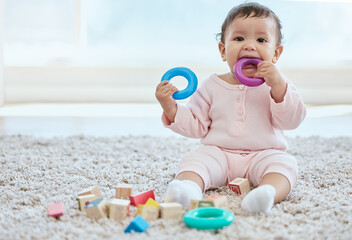 Poster - Baby, portrait and playing with toy on floor in home for sensory development, teething progress and biting. Infant, person and silicone ring in mouth for tooth growth, gums satisfaction and chewing