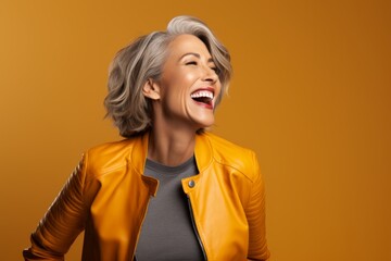 Wall Mural - Portrait of a joyful woman in her 50s wearing a trendy bomber jacket isolated on solid color backdrop