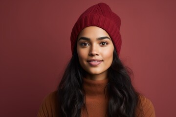 Sticker - Portrait of a content indian woman in her 20s donning a warm wool beanie isolated in solid color backdrop