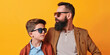 © Pierre Villecourt - Stylish Father and Son Wearing Sunglasses Against Orange Background