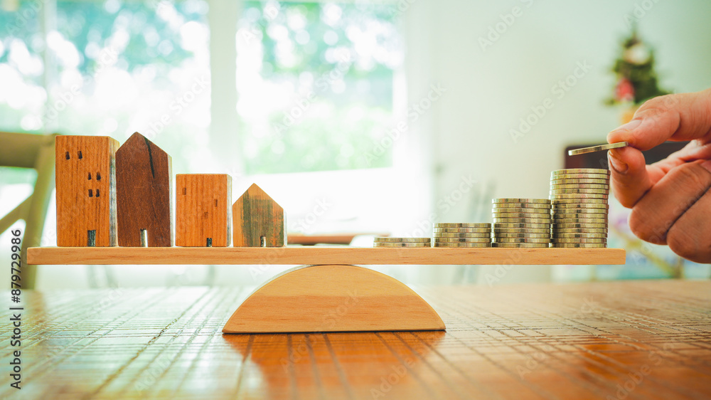 Wood house and Coins stack with balance scale. Money management ...