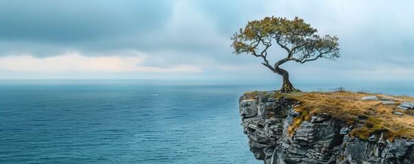 Wall Mural - A solitary tree standing tall on a windswept cliff overlooking the vast expanse of the ocean, its branches reaching towards the sky.