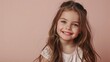 © Leli - A young girl with long brown hair smiles warmly against a soft pink backdrop