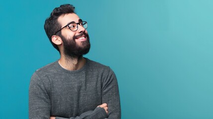 Young handsome man with beard wearing casual sweater and glasses over blue background smiling looking to the side and staring away thinking. 