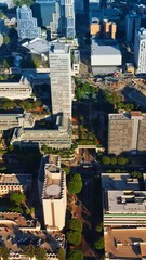 Wall Mural - Rising above sunlit Los Angeles downtown. Crazy traffic on the roads of metropolis from aerial view. Vertical video