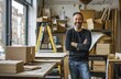 © Georgii - Portrait of a smiling man standing with arms crossed in a creative studio setting