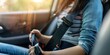 © Iswanto - Close-up of a woman's hand fastening a seatbelt in a car.