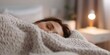 © Anastasiia - Creating a Peaceful Environment in the Bedroom to Enhance Sleep with a Weighted Blanket and Cozy Lighting. Concept Cozy Bedroom Decor, Weighted Blanket Benefits, Sleep Enhancing Tips